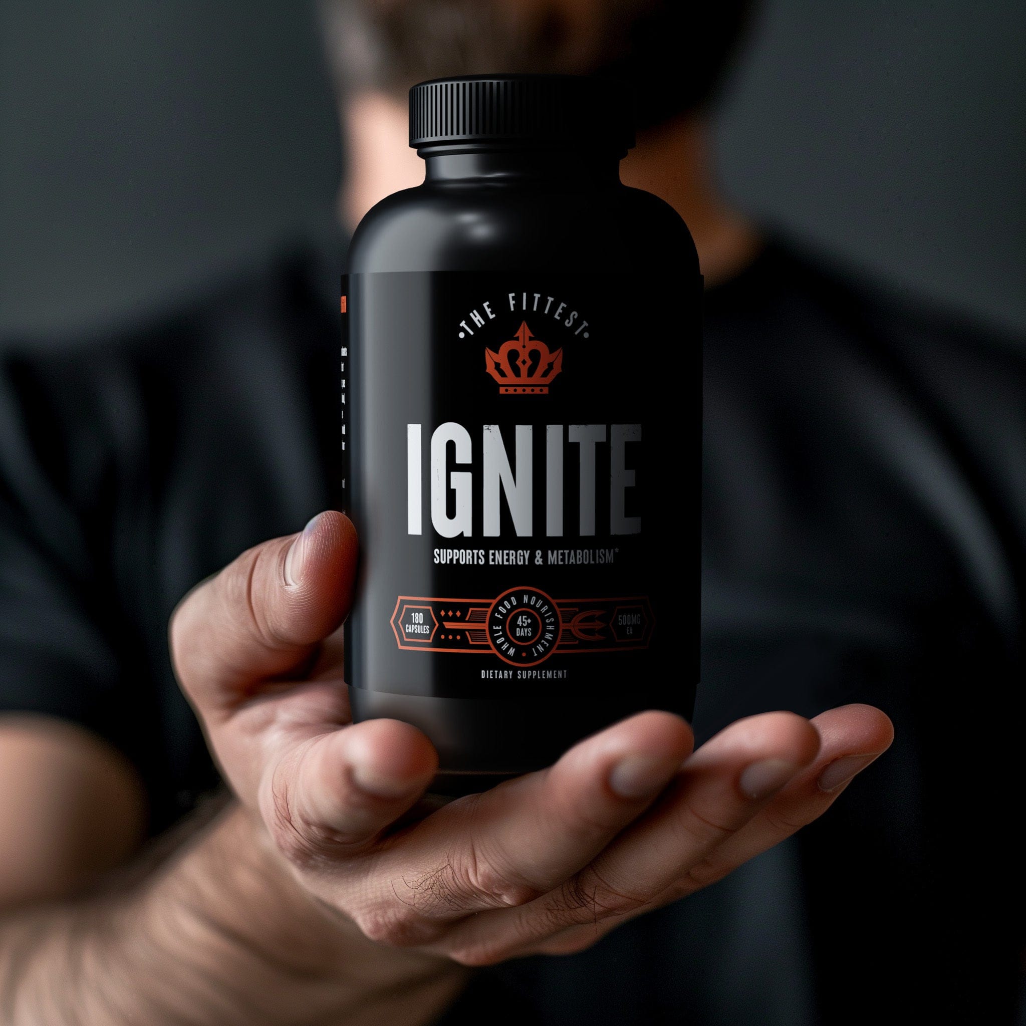 Man in black shirt holding out his hand presenting a bottle of Ignite